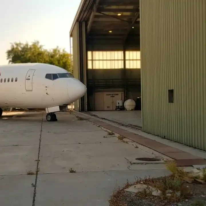 Boeing 737 parked beside the hangar entrance at the Dolphin Air facility, Sharjah International Airport